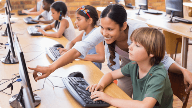 Hispanic female computer science teacher with students in the classroom